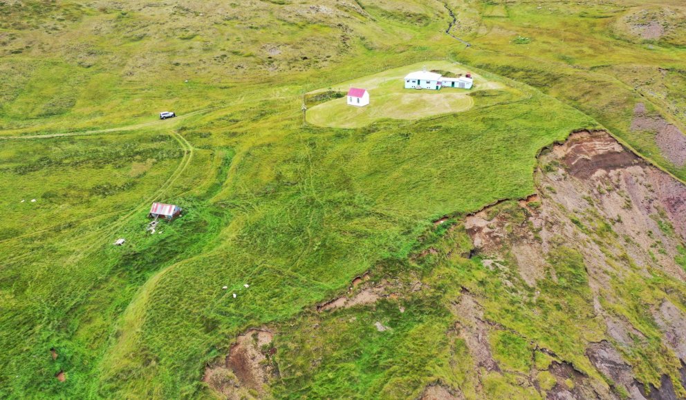 Heimatúnið við Húsavík, veggir gamla kirkjugarðsins neðarlega til vinstri á mynd og gamla bæjarstæðið þar fyrir ofan. Ljósmyndari Indriði Skarphéðinsson